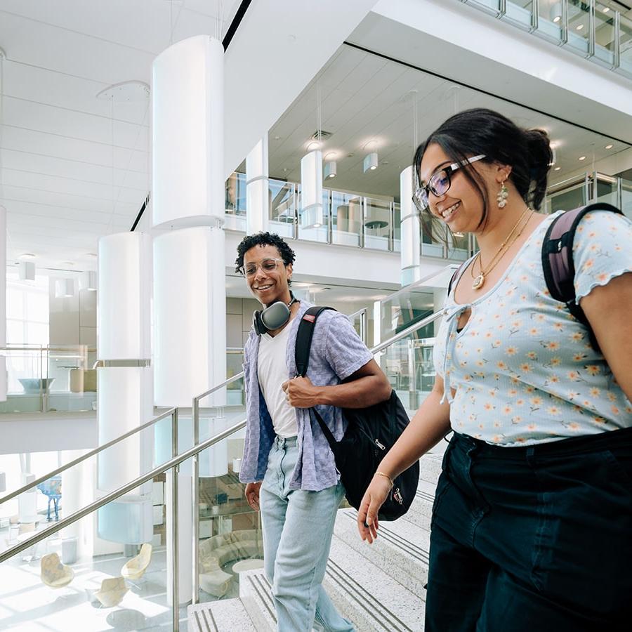 Two UMass Boston students walk down the stairs in the Integrated Sciences Complex